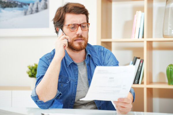 distressed man on phone looking at paper
